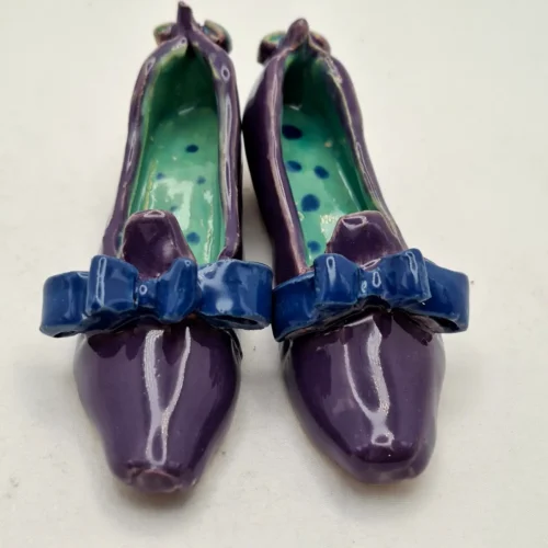 Buty ceramiczne seria sklep obuwniczy, prezent dla miłośników butów i ceramiki, prezencik ceramiczny. Fioletowe pantofelki z kokardami seria Sklep obuwniczy